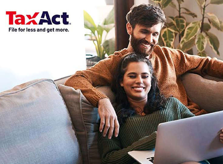 Couple sitting on couch with laptop; TaxAct logo in left corner Couple sitting on couch with laptop; TaxAct logo in left corner